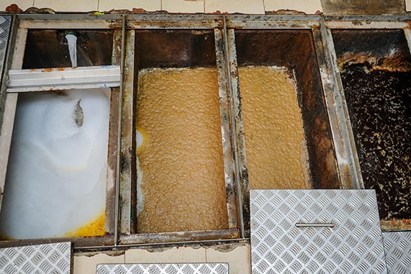 grease trap maintenance involves removing built-up grease and solids from the trap to prevent blockages